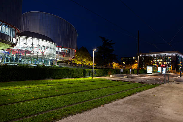 European Court of Human Rights at dusk Strasbourg, France - October 23, 2013: Facade and tram station of European Court of Human Rights at night. The European Court of Human Rights is an international court established by the European Convention on Human Rights, it is located in Strasbourg, France european court of human rights stock pictures, royalty-free photos & images