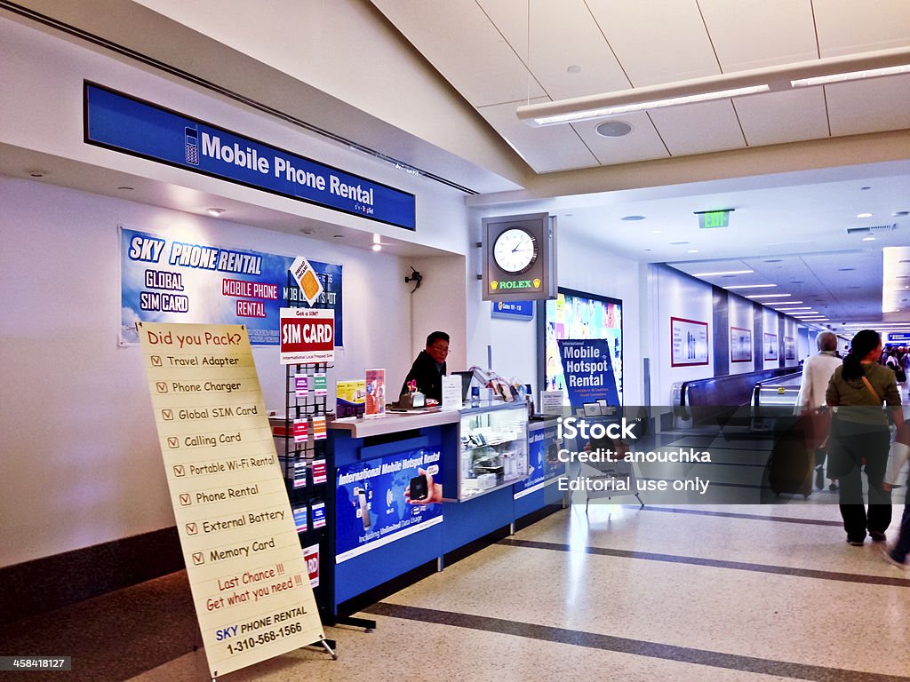 Mobile Phone Rental Service at Los Angeles Airport Los Angeles, USA  - June 6, 2013: Mobile Phone Rental Service at Los Angeles Airport. People with luggage walking, vendor waiting for clients. Adult Stock Photo