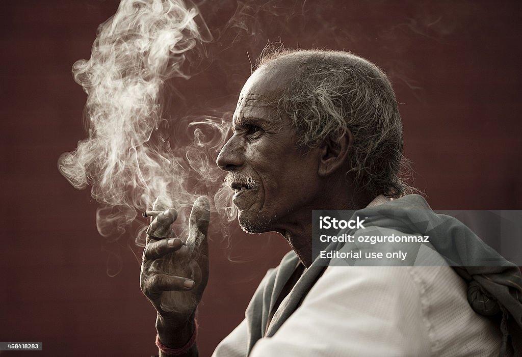 Indian man smoking Rishikesh, India - April 12, 2010: Portrait of an Indian man smoking on the street in Rishikesh, India Smoking - Activity Stock Photo