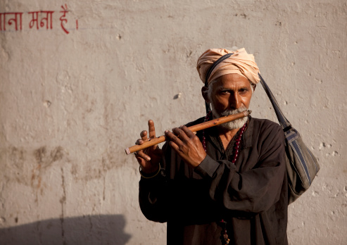 Rishikesh, India - April 12, 2010: Indian pilgrim playing flute during Kumh Mela in Rishikesh, India