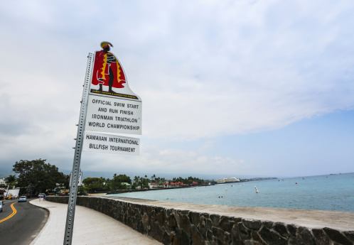 Kona, Kailua-Kona, Hawaii, USA - June 4th, 2012: Sign marking the start and finish line of the Ironman World Championship stands along the shoreline of Kailua Bay. The Ironman World Championship is one of the premier long distance triathlons.