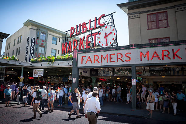 Shoppers and tourists visit Pike Place Market in Seattle, Washington. stock photo