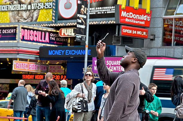 New York City, USA - April 14, 2011: A man is seen using a cellphone to capture a photo of the activities and surroundings of Times Square, Midtown Manhattan.
