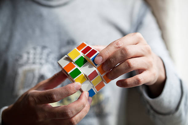 Hands playing a cube game Shanghai, China - Oct 27, 2013: Hands playing a Rubik's Cube game.Rubik's Cube is a 3D mechanical puzzle invented in 1974 by Hungarian sculptor and professor of architecture Erna Rubik puzzle cube stock pictures, royalty-free photos & images