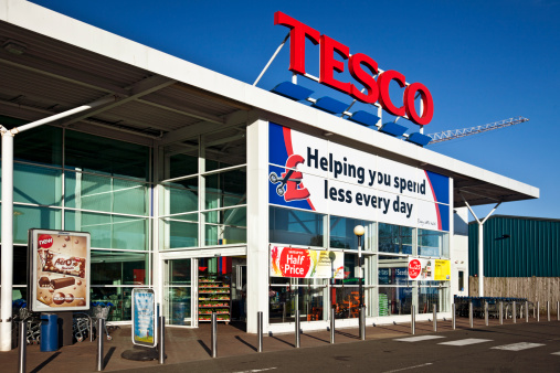 Kilbirnie, Scotland, UK - 1st May, 2011: The main entrance to a Tesco Superstore in North Ayrshire. There is a slogan banner and several sale banners, opening times poster and an advertisement for Aero chocolate. Tesco is the UK\\'s largest supermarket chain.