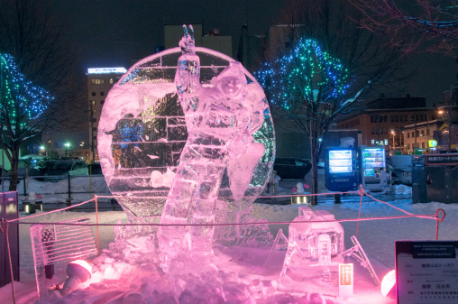 Asahikawa, Japan - February 9, 2013: The 45th Asahikawa Winter Festival. Photo showing a sculpture of apollo astronaut first arriving at the moon surface with the theme `the earth is blue`. The Asahikawa Winter Festival (Asahikawa Fuyu Matsuri) is Hokkaido's second largest winter festival after Sapporo's Snow Festival. The festival takes place over a week in early February, about the same time as the Sapporo Snow Festival. Ice sculpture competition is held along with the asahikawa winter festival.