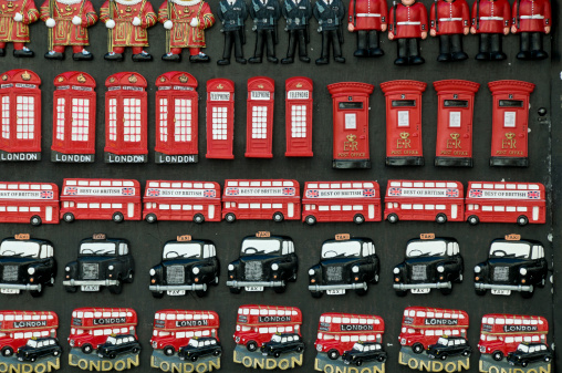 London, England - October 1, 2009: Variety of badges and fridge magnets souvenirs on sale on a market stall in Piccadilly, London depicting iconic English images such as the classic London taxi and telephone boxes