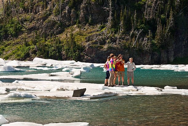 Standing on an Iceberg Glacier National Park, Montana, USA - August 16, 2013: A group of young people drink beer while standing on the ice at Iceberg Lake. jeff goulden glacier national park stock pictures, royalty-free photos & images