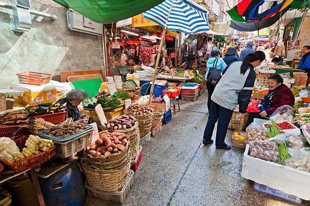 épicerie vendant des légumes rue animée de hong kong, en chine - store market china city street photos et images de collection