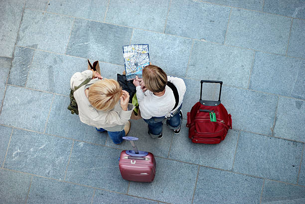 Liverpool, England - July 13, 2008: Lost tourists with luggage looking at Liverpool map.