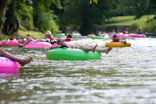 Helen, GA, USA - August 24, 2013:  Dozens of people enjoy tubing down the Chattahoochee River in North Georgia on a warm summer afternoon.