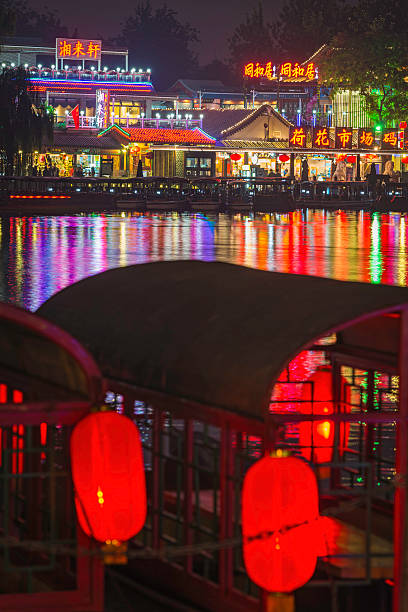 Old fashioned carousel at night on Christmas market in amusement park.\n\nDefocused illuminated abstract background with multi colored. Blurred merry-go-round in a funfair background.