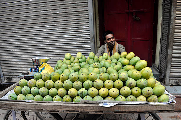 Selling Mango in Old Delhi Delhi, India - July 9th, 2011: Young man selling mango in Dariba Kalan Street in Old Delhi. old delhi stock pictures, royalty-free photos & images