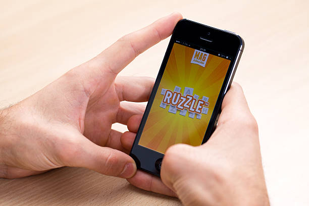 ruzzle auf iphone 5 mit ios 7 - holding iphone 5 business mobile phone stock-fotos und bilder