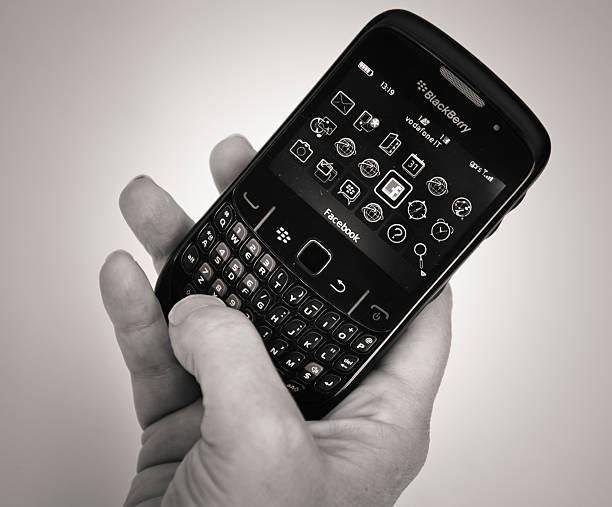 Florence, Italy - March 26, 2011: Hand holding a Blackberry smartphone with mobile version of www.facebook.com site. Facebook is a social networking website, owned by Facebook, Inc., for free access. It is the second most visited site in the world, preceded only by Google. The smartphone is a Blackberry Curve 8520. BlackBerry is a trading name of a series of portable smartphone produced by Canadian company Research In Motion (RIM).