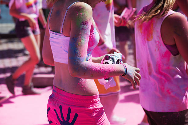 running women at the Color Run in Cologne Cologne, Germany - July 21, 2013: competitors at a ColorRun in Cologne, Germany. Color Run is since a few years a world wide upcoming charity event with fun character. The competitors are sprayed with color powder. cologne germany stock pictures, royalty-free photos & images