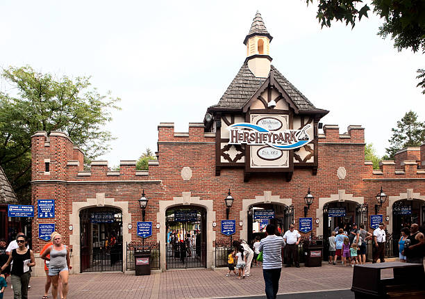 Entrance to Hersheypark Amusement Area Hershey, PA, USA - July 23, 2011: Visitors outside the entrance gates to Hersheypark, with over 60 rides and attractions. Hersheypark was created in 1907 with a baseball diamond, bandstand and picnic area for employees of the Hershey Company. Rides and amusements were gradually added over the years, and eventually opened to the public. terryfic3d stock pictures, royalty-free photos & images