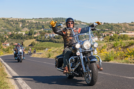 Riolo Terme (RA) Italy - September 22, 2013: a happy driver leads a group of bikers riding Harley Davidson at motorcycle rally 