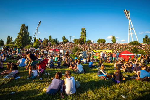 Berlin, Germany - June 21, 2013: People sitting on grass in Mauerpark listening to the Feta De La Musique events, Prenzlauer Berg, Berlin, Germany.