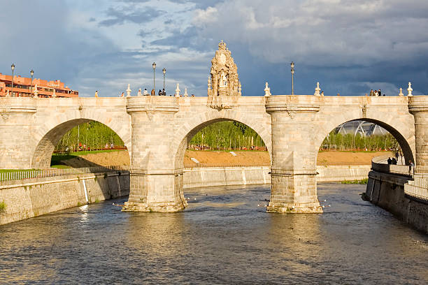 Madrid, Spain - Apr 23, 2011: People walking through the old brigde of Toledo, over the Manzanares river. It was built between 1718 and 1732.