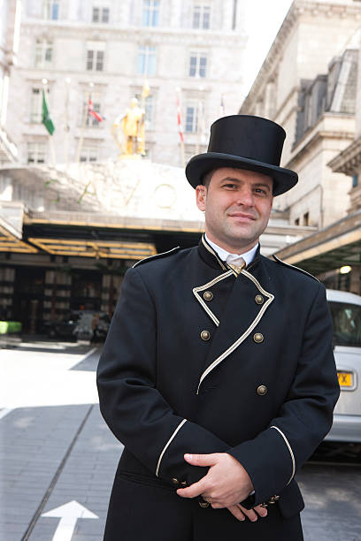 London, United kingdom - May 1, 2011 : traditionally dressed concierge standing in front of the Savoy Hotel, Strand, London to find cabs for hotel guests and to manage traffic to and from the hotel entrance.