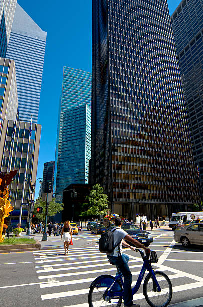 bicyclist & architektur in midtown manhattan skyline, new york city - caucasian three dimensional shape men sky stock-fotos und bilder