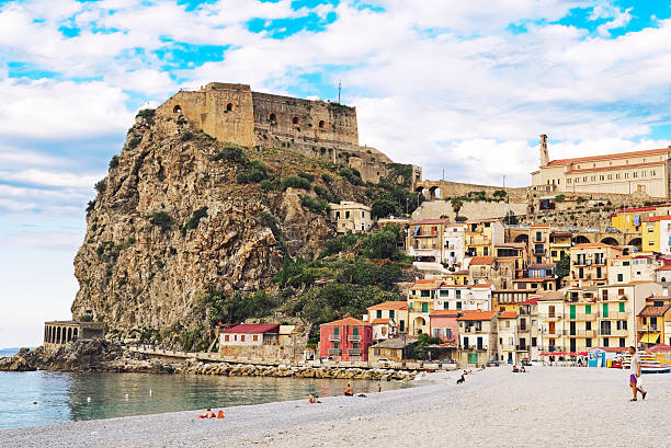 Beach in Scilla Scilla,Calabria,Italy - September 22, 2013: Beach in Scilla, a town located in the province of Reggio Calabria in Southern Italy. View on the rock with Ruffo Castle and the beach front ( Marina Grande) and colorful houses. Some tourists relaxing on the beach. castle scilla stock pictures, royalty-free photos & images