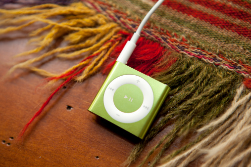 Portland, Oregon, USA - May 24, 2011: Apple iPod Shuffle, 4th Generation, is the very small portable mp3 player that will play your music, podcasts or audio books with the new VoiceOver function to help with navigation between songs and playlists.