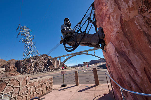 High Scaler Monument at Hoover Dam Boulder City, Nevada, USA - April 5, 2011: High Scaler Monument at Hoover Dam is a bronze statue depicting the most dangerous job on the project--setting explosive charges and removing loose rock from the canyon walls up to 900 feet above the Colorado River. hoover dam statues stock pictures, royalty-free photos & images