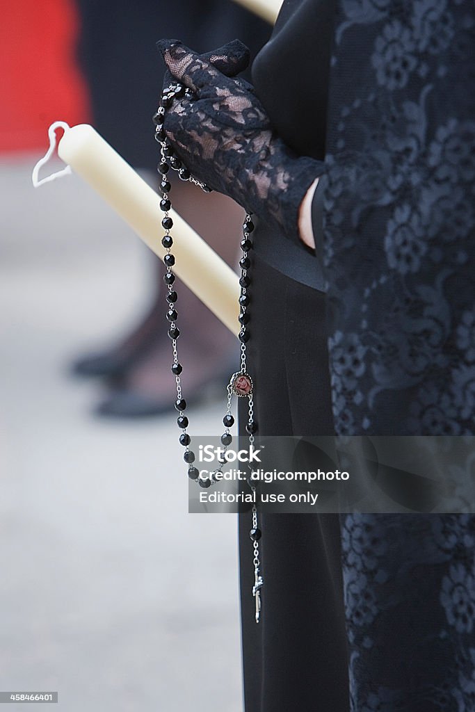 Detail of a woman dressed in mantilla Linares, Jaen, SPAIN- April 4, 2010: Woman dressed in mantilla during a procession of holy week, The mantilla is a popular spanish garment consisting of a elegant female headdress of clicks to parade in procession doing penance, the shawls are usually carry a lighted candle while praying the rosary, Linares, Jaen province, Andalusia, Spain Dress Stock Photo