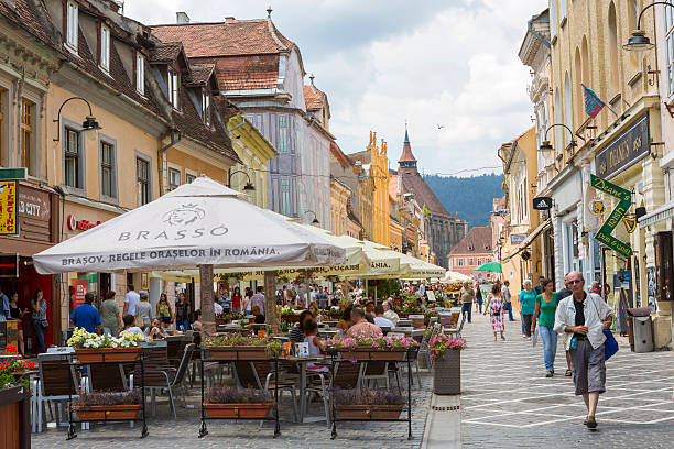 Brasov, Romania - July 26, 2013: Crowded cafes and people strolling down the Republic Street on July 26, 2013 in Brasov, Romania. Brasov is the 7th largest city and the most visited in Romania.