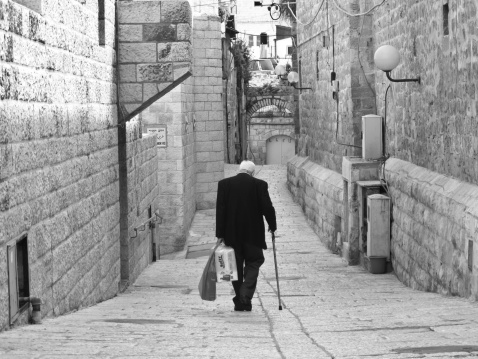 Jerusalem, Israel - March, 30th 2013: Old jewish man walking on the street to going his home after shopping. Jerusalem old city, Israel.