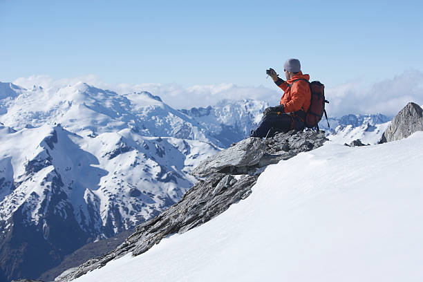 istock Climber Taking Picture Of Snowy Mountains 458468885