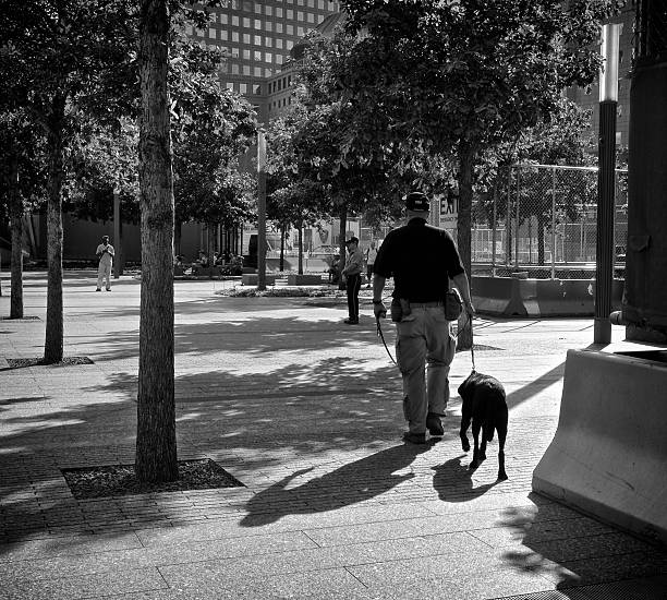 New York City, USA - August 27, 2013: A Counter-Terror K-9 Team walking around the National September 11 Memorial plaza area at Ground Zero, World Trade Center, Lower Manhattan.