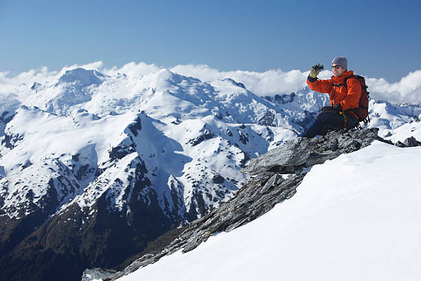 istock Climber Taking Picture Of Snowy Mountains 458469337