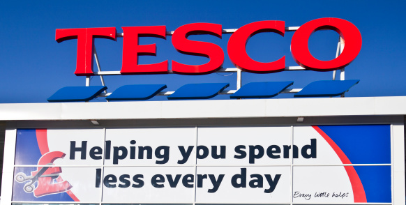 Kilbirnie, Scotland, UK - 1st May, 2011: A sign above the entrance of a Tesco superstore in North Ayrshire, with a banner with a brand slogan underneath. Tesco is the leading supermarket brand in the UK, having been founded in 1919 and now has branches in 14 countries worldwide.