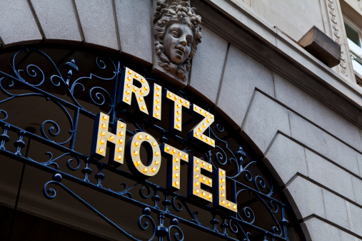 London, United Kingdom - April 29th 2011: The Ritz Hotel logo, illuminated with light bulbs and mounted on wrought iron work under the front arches of the Ritz building, Piccadilly, London, UK. The Ritz, opened in 1906, is a luxury hotel and international landmark in the west end of London.