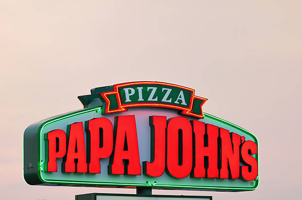 Illuminated Papa John's Pizza Sign at Sunset stock photo