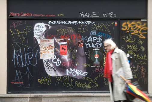 Paris, France - November, 17th 2009:Man passing in front of a wall covered with many graffitis.