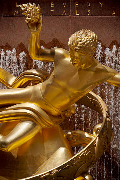 New York City, USA - May 16, 2010: Gold Statue of Prometheus and fountain in lower plaza of Rockefeller Center. Close up on sculpture and fountain, vertical shot.