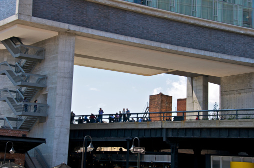 New York City, USA - April 24, 2011: People are seen gathered on the High Line elevated park underneath the Standard Hotel, Washington Street in the Meatpacking District.