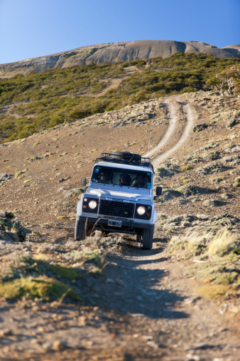 Calafate, Argentina - February 14, 2010: Group of tourists making a off-road safari through the wilderness of Patagina, Argentina near the town of Calafate.They drive a Land Rover Defender which is a British four wheel drive off-road utility vehicle. The original Land Rover Series launched in 1948 - The defender in 1990.