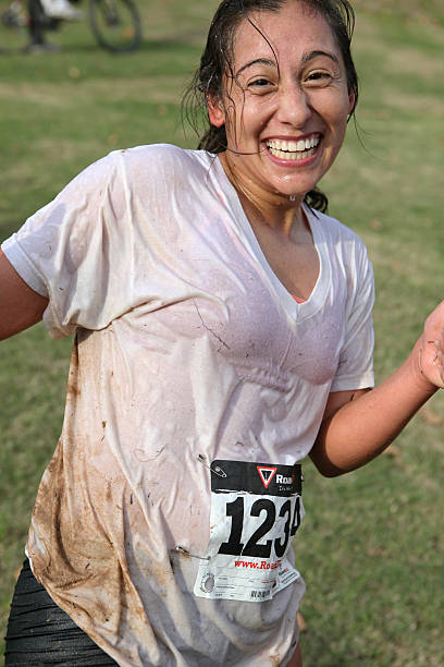 Little Rock, USA aa October 26, 2013: A female participant was smiling near the finish line of a charity Mud Run at Two Rivers Park in Little Rock, Arkansas, USA on October 26, 2013. A few hundred fun-loving runners participated in Mud Run 2013 where runners had to cross a 300-foot mud pit to finish the 5K course. This event benefited the Little Rock Parks and Recreation Department.