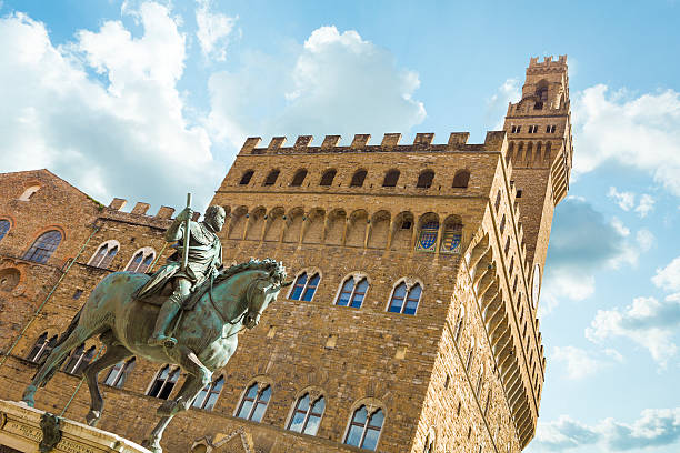 Florence, Italy - June 25, 2013: Equestrian statue of Cosimo de Medici  is on the left side and Palazza Vecchio on the background. It's placed on the piazza della Signoria, Florence, Italy. 