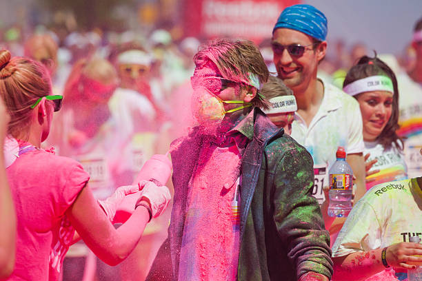 spraying pink powder at the Color Run in Cologne Cologne, Germany - July 21, 2013: competitors at a ColorRun in Cologne, Germany. Color Run is since a few years a world wide upcoming charity event with fun character. The competitors are sprayed with color powder. cologne germany stock pictures, royalty-free photos & images