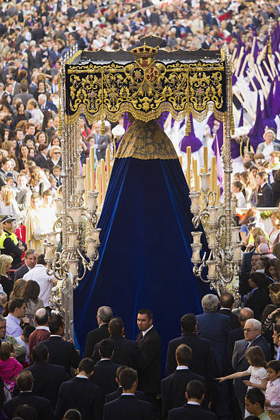 Virgin religious parade during Maundy Thursday in Sevilla Seville, Spain - April 9, 2009: Virgin float and religious parade (Virgin of Ntra. Sra. De la LA!grimas, ExaltaciAn Brotherhood) during the Holy Week surrounded by a crowd of visitors, penitents and spectators while leaving Sierpes street for the last tram of the parade before entering the Cathedral of Seville. 2001 stock pictures, royalty-free photos & images
