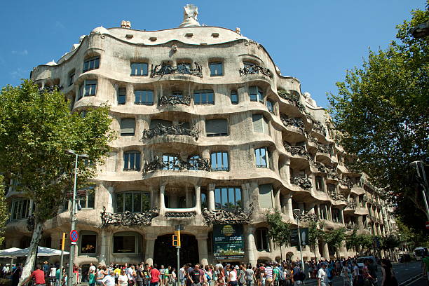 Casa Mil (La Pedrera) Barcelona, Spain - August 13, 2013: Pedestrians walking around Casa Mila, well known as "La Pedrera" is a very uncommun building constructed between 1906 and 1912 by the architect Antoni Gaudi. Was declared UNESCO World Heritage in 1984. casa mil�� stock pictures, royalty-free photos & images