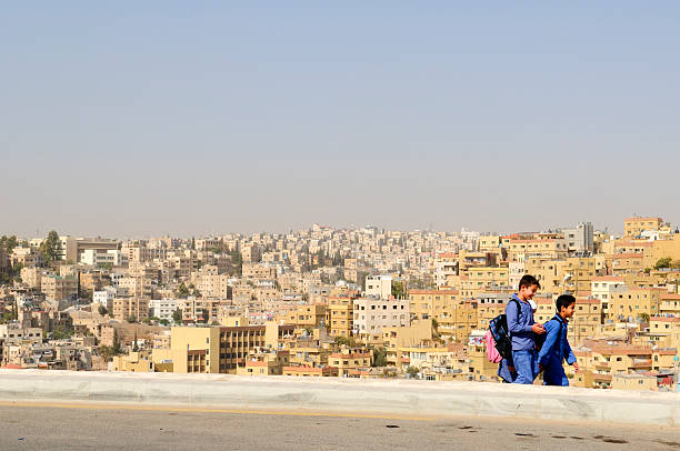 Amman, Jordan - November 10, 2010: Two boys and a girl, wearing their school backpacks, walk home after a day of classes in this hilly Jordanian capital. Amman is home to an estimated 2.1 million people.