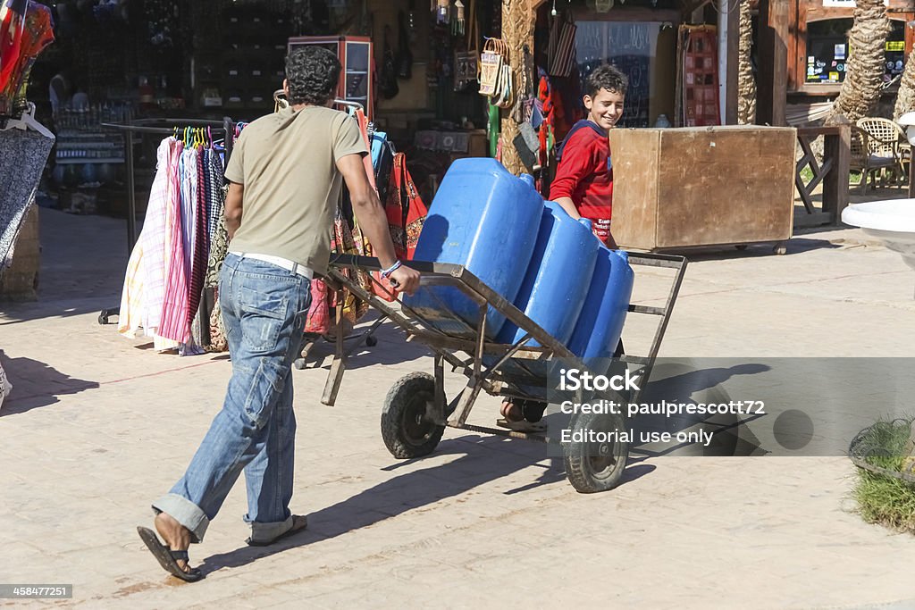 Due uomo spingendo il carrello - Foto stock royalty-free di Addetto ai traslochi