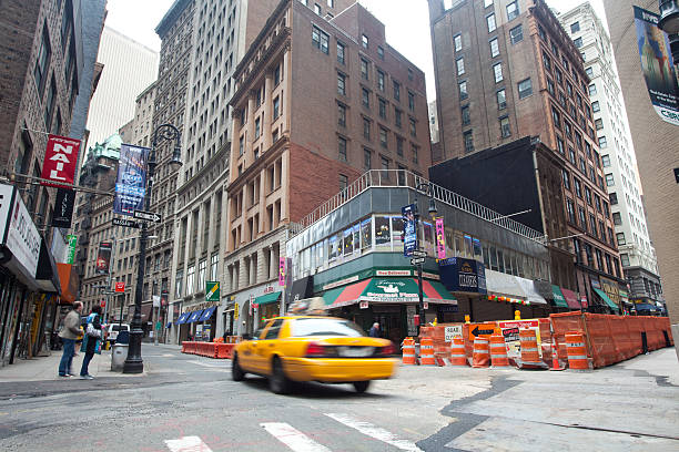 Yellow taxi passing through Nassau Street and Maiden Lane intersection New York City, USA - April 10, 2011: Yellow taxi passing through Nassau Street and Maiden Lane intersection. Various businesses are seen serving Manhattan's financial district. Nassau Street is closed for construction. nassau street stock pictures, royalty-free photos & images